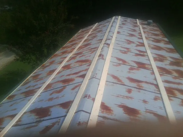 Rusted metal roof panels with new wood purlins before replacement — Storm Damage Roof Repair in Burlison by Roofing Brothers