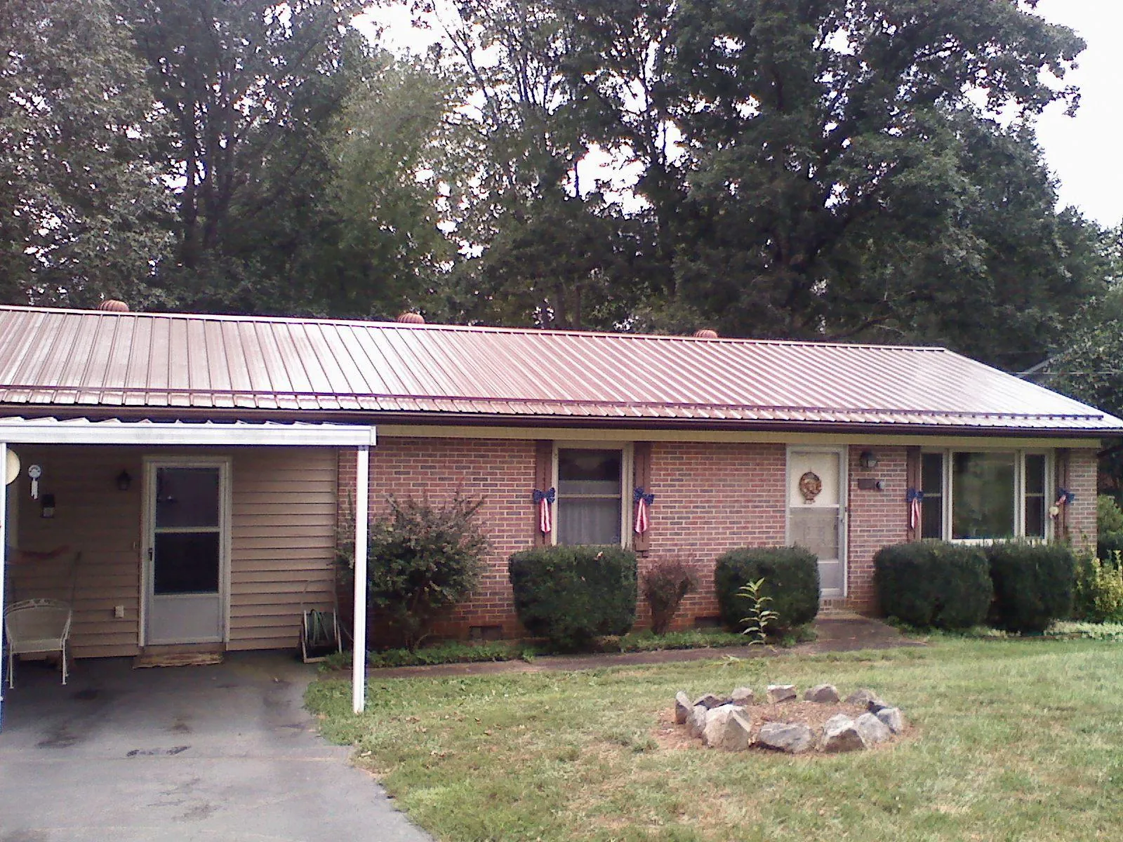 Bronze metal roof and carport on a brick ranch home — Roof Repair work by our crew in Burlison